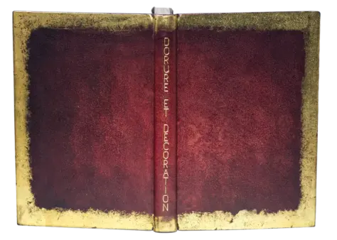 Einband mit offenem Falz, braunem Lederrücken, roter Heftung und Deckeln aus Stein, dekoriert mit geschmolzenem Metall.
