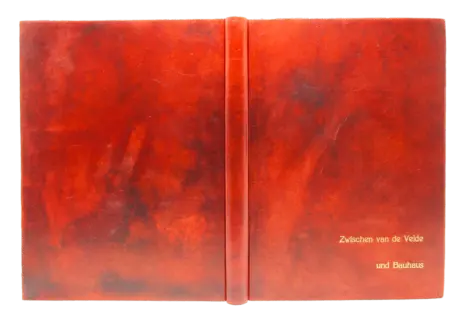 Einband mit offenem Falz, braunem Lederrücken, roter Heftung und Deckeln aus Stein, dekoriert mit geschmolzenem Metall.